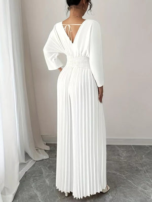 White pleated wide-leg jumpsuit with cinched waist and tie-back detail.