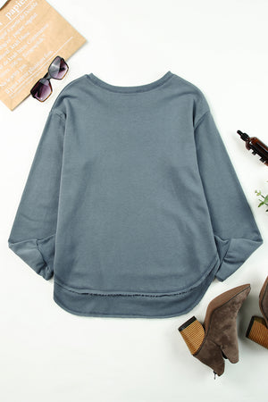 Dull blue sweatshirt with asymmetric hemline and raw edge detail.