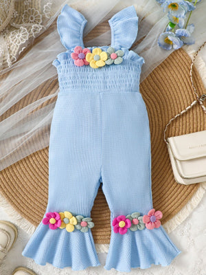 Baby blue cotton smocked jumpsuit with floral applique on bodice and flared legs.