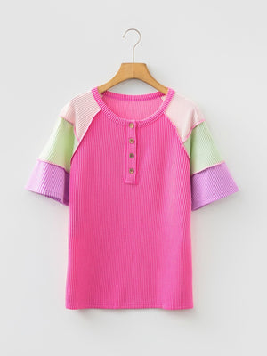 Color block patchwork henley t-shirt in fuchsia pink with pastel sleeves and button detail.