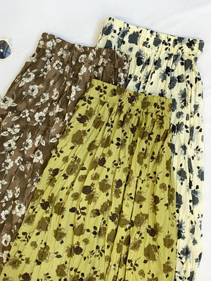 Botanical print midi skirts in olive, tan, and black with crinkled fabric and elastic waistbands.