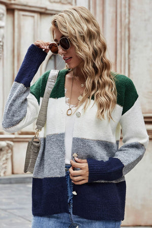 Colorblock acrylic cardigan with metallic trim in green, white, grey, and dark blue.