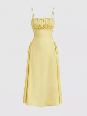 Light yellow cami dress with ruched bodice and crisscross lace-up sides.