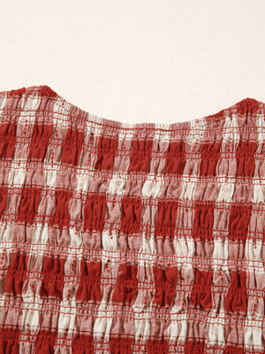 Red and white gingham smocked mini dress with puff sleeves.
