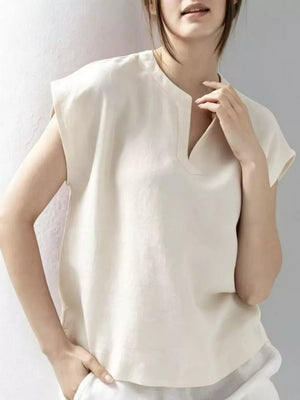 White cap sleeve shirt with notched neckline and relaxed fit.