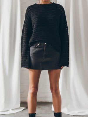 Black open-knit sweater with bell sleeves and a crew neck.