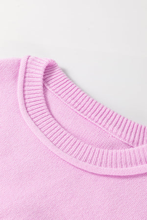 Pink knit sweater with contrast stitching detail on neckline and cuffs.