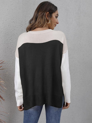 Colorblock crewneck knit sweater in black, cream, and white with side slits.