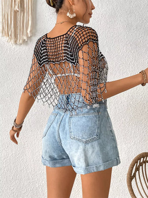 Black crochet cardigan with beaded details and cutout pattern, worn over a white bralette.