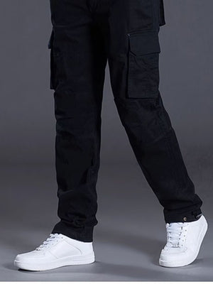 Men's black relaxed fit cargo pants with multiple pockets, styled with white sneakers.