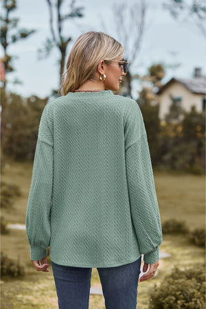Sage textured cable knit V-neck sweater with long sleeves.