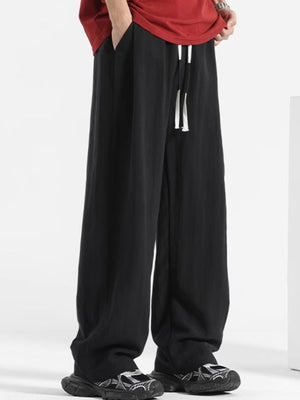 Men's black relaxed fit sweatpants with white drawstring and pockets.