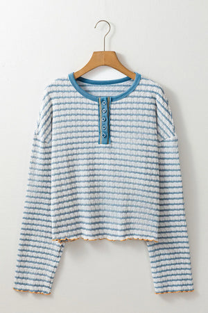 Textured stripe henley sweater in dusty blue with button placket and lettuce hem detail.
