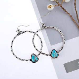 Southwestern stone hoop earrings in silver with turquoise inlay and textured details.