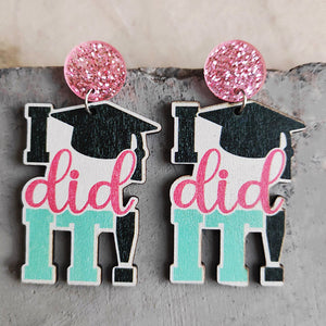 Graduation drop earrings with pink glitter tops and "I did it" text.