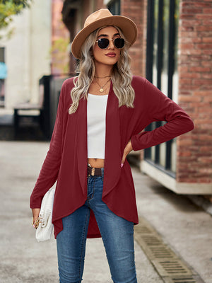 Draped cascade cardigan in wine with open front and long sleeves, styled with jeans.