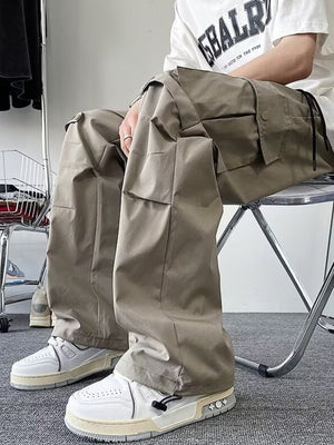 Khaki wide-leg cargo pants with multiple pockets and drawstring detail, worn by a man.