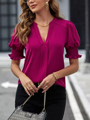 Sophisticated notched blouse in Cerise with puffed sleeves and smocked cuffs.