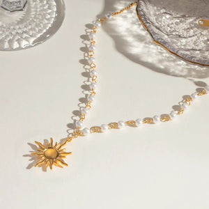 Gold celestial sun pendant necklace with pearl and chain detail