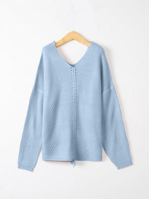 Pastel blue slouchy knit sweater with V-neck and lace-up detail at hem
