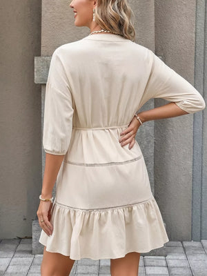 Apricot cotton V-neck mini dress with button details, tiered ruffles, and a cinched waist.