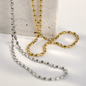 Dual-tone capsule chain necklace in gold and silver with oval bead links.
