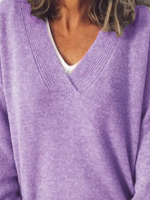 Relaxed lavender ribbed knit sweater with V-neck, layered over a white top.