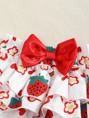Baby set with tiered ruffles, strawberry and flower print, and a red bow detail.