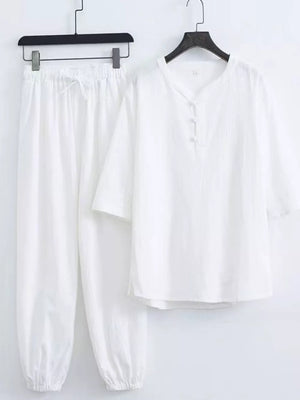 White relaxed fit Chinese-inspired men's pants set with drawstring waist and button-up top.