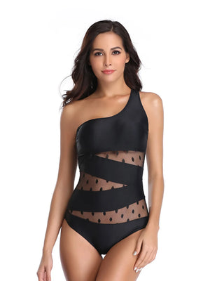 Black one-shoulder swimsuit with sheer polka dot mesh insets and diagonal straps.