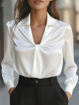 White long-sleeve blouse with ruched front and collar, styled with black pants.