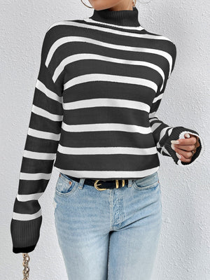 Oversized black and white striped turtleneck sweater with ribbed cuffs.