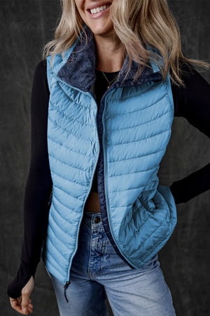 Pastel blue quilted puffer vest with navy fleece collar and zipper detail