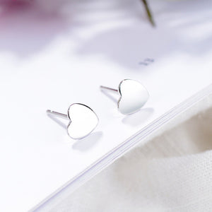 Elegant heart-shaped sterling silver stud earrings with butterfly backs.