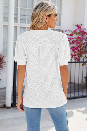 White eyelet V-neck blouse with puff sleeves and a diamond pattern.