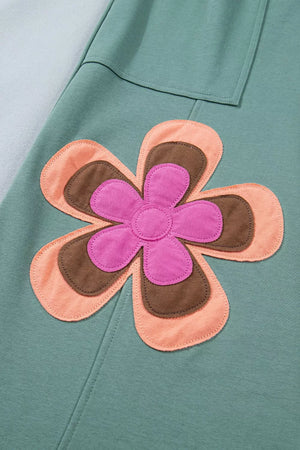 Green cotton sweatpants with a colorful floral applique detail.