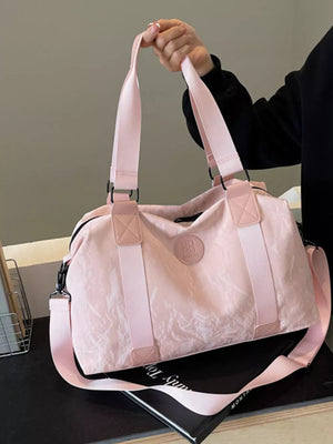 Chic medium blush pink Oxford cloth travel bag with textured finish and dual straps.