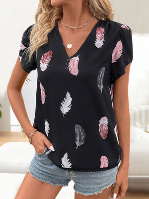 Black feather print blouse with V-neck, puff sleeves, and button detail