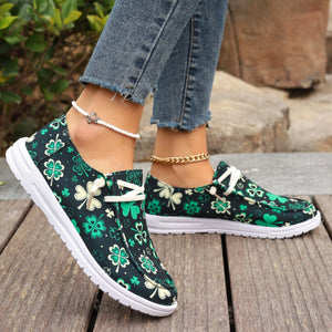 Clover print canvas slip-on sneakers with decorative laces and white soles.