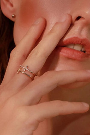 Double band ring with rhinestone cross embellishment in gold.