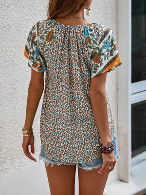 Bohemian floral print blouse with flutter sleeves and a gathered neckline, shown in multicolor.