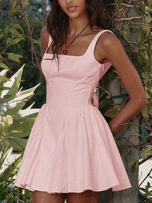 Blush pink mini dress with square neck, backless detail and bow accent.