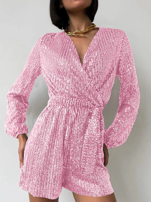 Pink sequin wrap romper with blouson sleeves and a V-neckline.