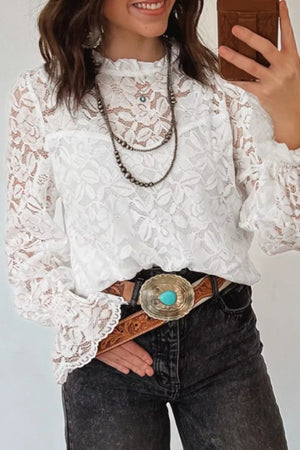White lace blouse with ruffled neckline and bell sleeves, styled with a turquoise concho belt.