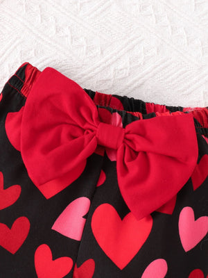 Baby pants with black heart print and red bow detail