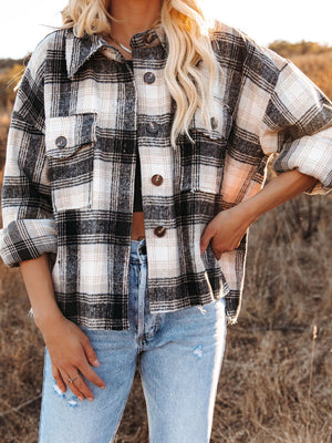 Plaid pocket long sleeve shirt jacket in black and cream with button front and collar.