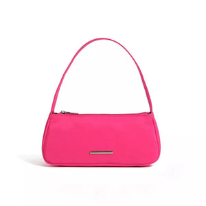 Sleek mini shoulder bag in bright pink nylon with a silver bar detail.