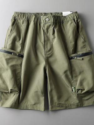 Green relaxed fit cargo shorts with elastic waist, button closure, and zippered pockets.