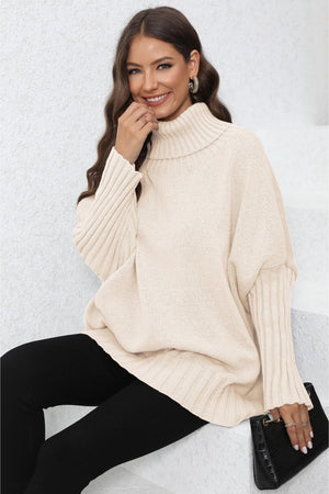 Beige ribbed turtleneck sweater with batwing sleeves and ribbed cuffs.