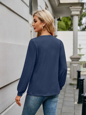 Navy long sleeve blouse with gathered sleeves and a textured finish.